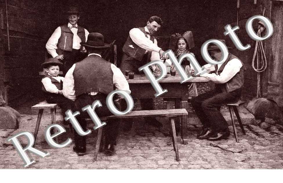 Quatre hommes et deux enfants a table  autour d&#039;un kouglof