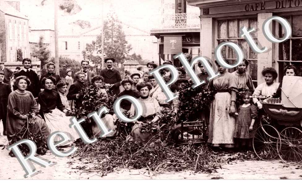 Femmes confectionnent des guirlandes de lierre devant le Cafe Dutot)