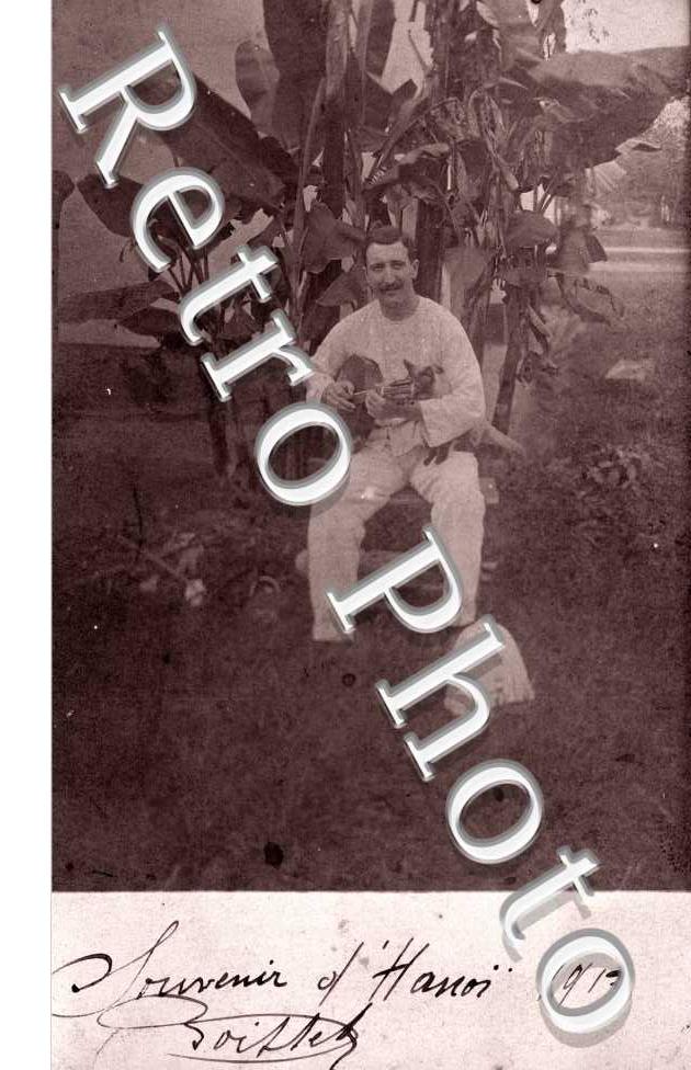 Un homme pose avec un instrument de musique devant une plante