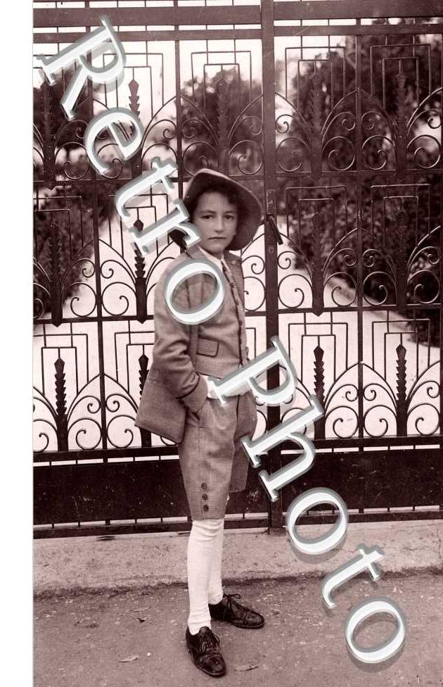 Un enfant posant devant une grille - Fotografo Maxxa Tirana