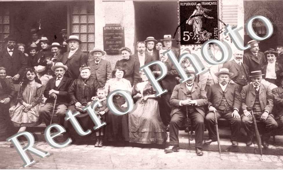 groupe de personnes devant une location de chambres meublees  et table d'hote