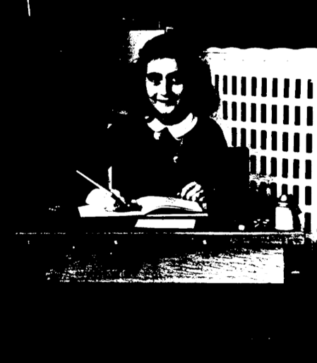 Anne Frank in einer Frontalaufnahme an einem Tisch sitzend, einen Stift in der rechten Hand mit einem aufgeschlagenen Heft vor sich. 

Anne Frank in 1940, while at 6. Montessorischool, Niersstraat 41-43, Amsterdam (the Netherlands). Photograph by unknown photographer.