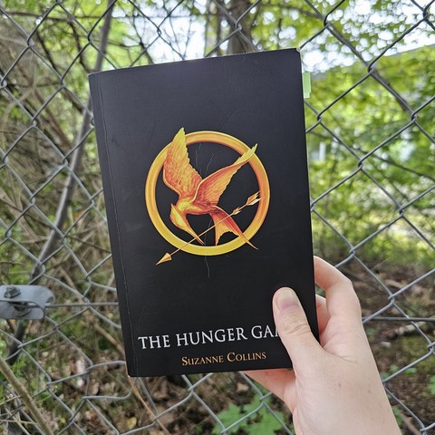 Suzanne Collins - The Hunger Games

Schwarzes Cover mit einem goldenen Vogel, der umrundet ist von einem goldenen Kreis uns im Schnabel einen Pfeil hält