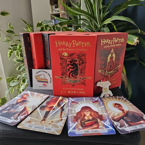 J.K. Rowling - Harry Potter and the Prisoner of Azkaban

Gryffindor House edition: Rotes Buch mit goldener Aufschrift. Auf dem Cover sieht man ein viereckigen Rahmen, der aus verzwirbelten angedeuteten Kupferstichverzierungen mit Andeutungen zum Wald und einem Hirsch. In der Mitte ein schwarzer Hund. Unten drunter auf einem schwarzen Banner steht nochmal Gryffindor in schwarzen Lettern.