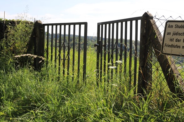 Eingangstor eines alten jüdischen Friedhofes, mit Gras zugewachsen