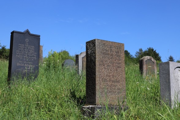 Jüdische Gräber auf einem Friedhof vor blauem Himmel