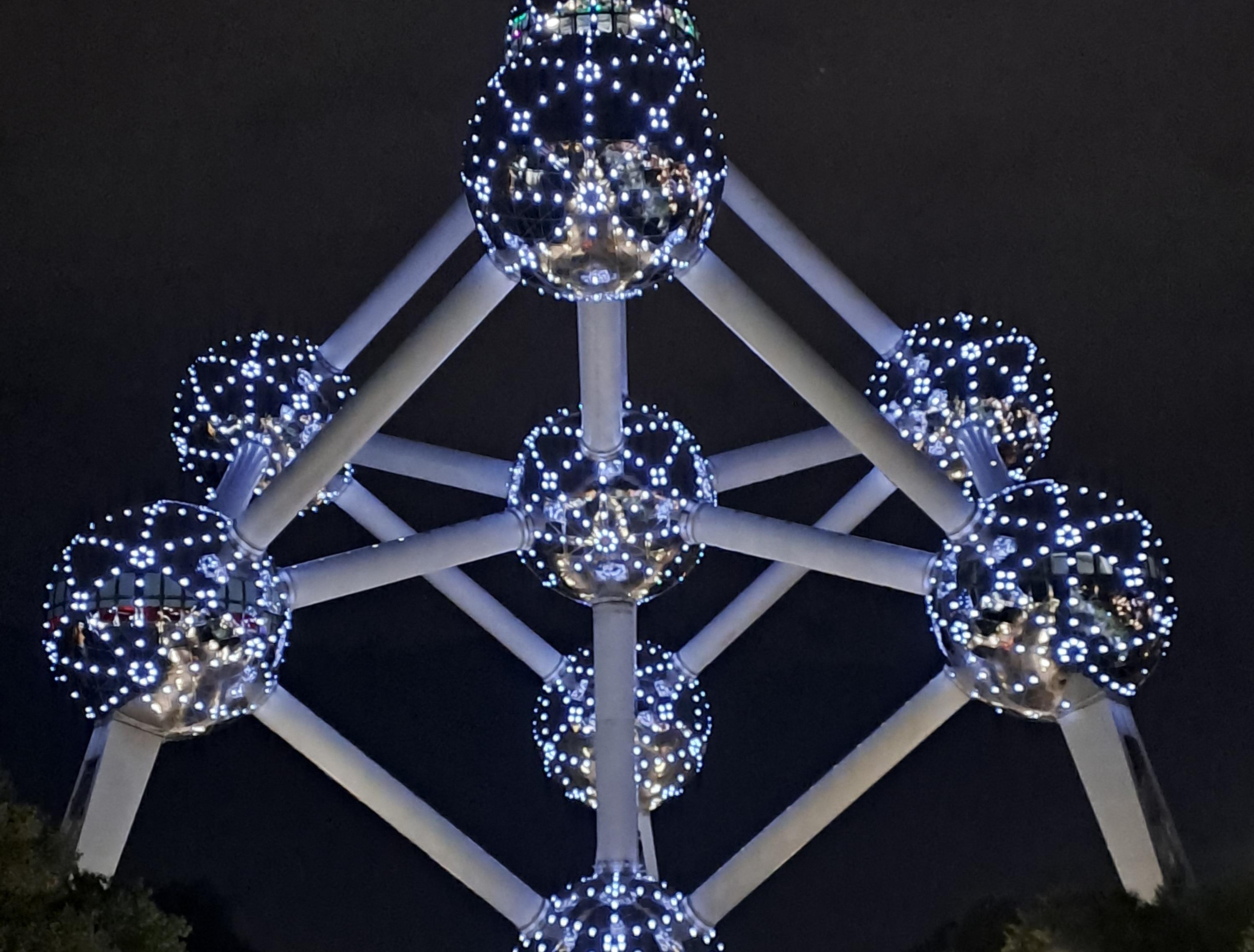 Das Atomium vor nachtschwarzem Himmel.
Die Kugeln sind kunstvoll beleuchtet, als wären weiße Lichternetze darum gespannt. Das Atomium vor nachtschwarzem Himmel.
Die Kugeln sind kunstvoll beleuchtet, als wären weiße Lichternetze darum gespannt.