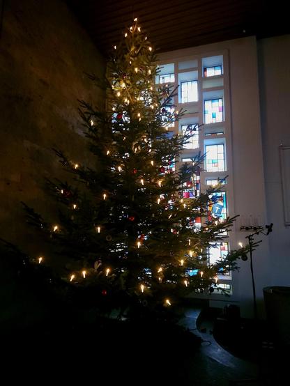 Christbaum in der Kirche mit leuchtenden Kerzen