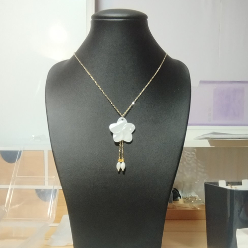 Collier en acier doré avec pendentif fleur en nacre sculptée et perle de nacre et d’acier