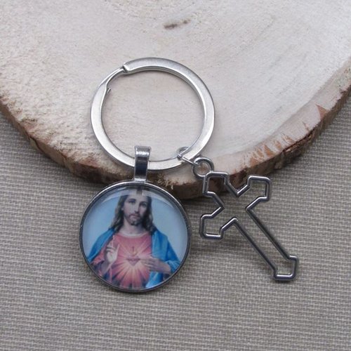 Porte-clés, bijou de sac jésus christ et croix en acier, fond bleu.