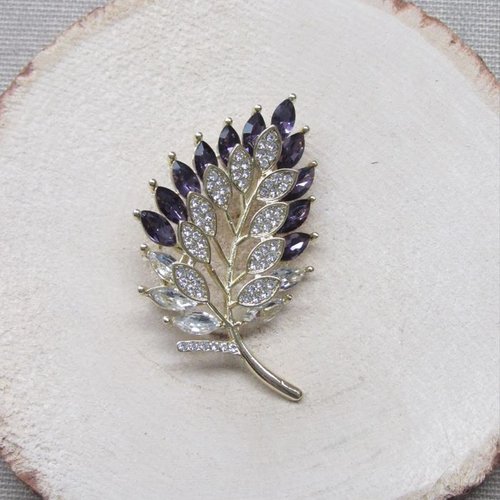 Broche style floral feuille en acier doré et strass cristal.