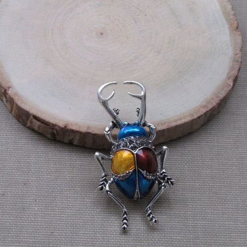 Broche bijou insecte coléoptère style scarabée bleu dominant.