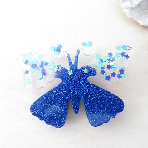 Broche papillon à paillettes bleu et petites fleurs irisées