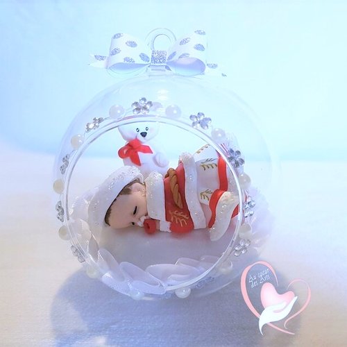 Boule de noël bébé fille dans sa bulle rouge et blanc - au cœur des arts.