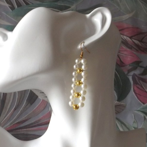 Une paires de boucles d'oreilles élégantes crées avec des perles de verre et pvc