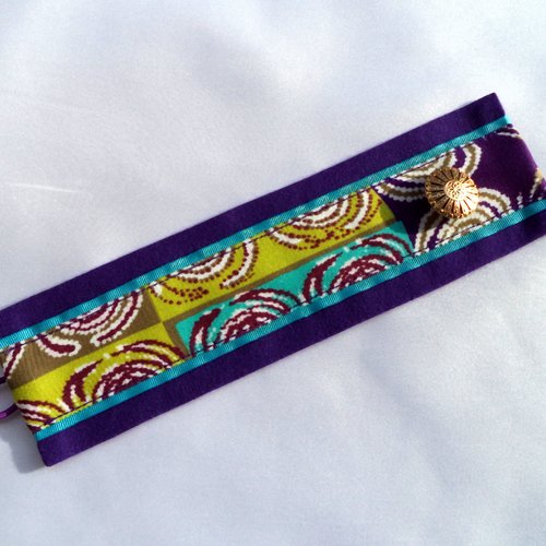 Bracelet manchette coloris violine , agrémenté de tissu aux couleurs assorties.