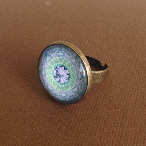 Bague en métal couleur bronze et cabochon de verre motif mandala vert et bleu 
