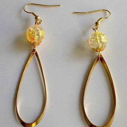 Boucles d'oreille avec perle translucide dorée jaune orangé et anneau doré oval. 