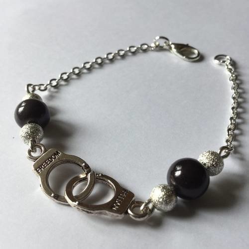 Bracelet "menottes" fin argenté avec menottes "freedom", perles et chainettes argentées. 