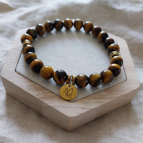 Bracelet extensible œil de tigre naturelle. perles heishi dorées et médaille en acier inoxydable gravée d’un papillon.