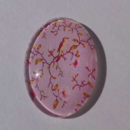 Cabochon de verre, ovale, 18x25 mm, oiseau sur sa branche sur un fond rose