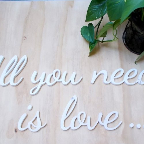 Phrase déco en bois brut  : all you need is love.