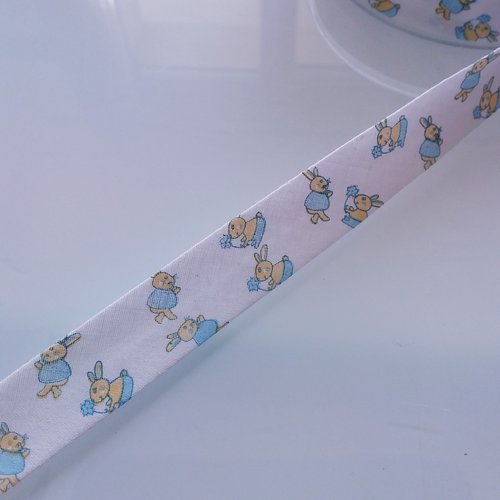 Biais motif enfant - 35% coton 65 % polyester - 2 cm de large - fond blanc motif lapin bleu et jaune - vendu au mètre