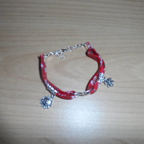 N°81 bracelet  en tissu  fond rouge  à fleurs blanches  et breloques  un soleil et une fleurs n°2