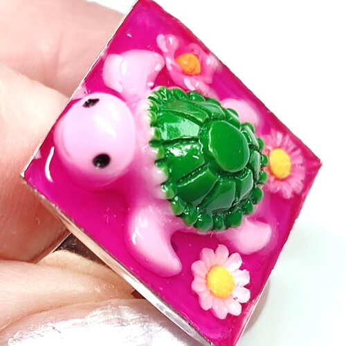 Bague "les biduleries" en résine sur support carré argenté réglable tortue et fleurs sur fond fucshia