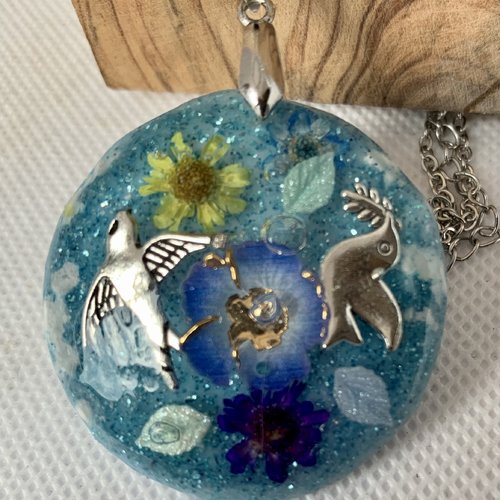Pendentif  en resine   fond bleu bleue , oiseau,fleurs, papillons,