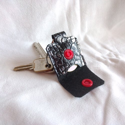 Un porte jeton simili cuir noir aspect croco et son anneau, noir & gris bouton rouge