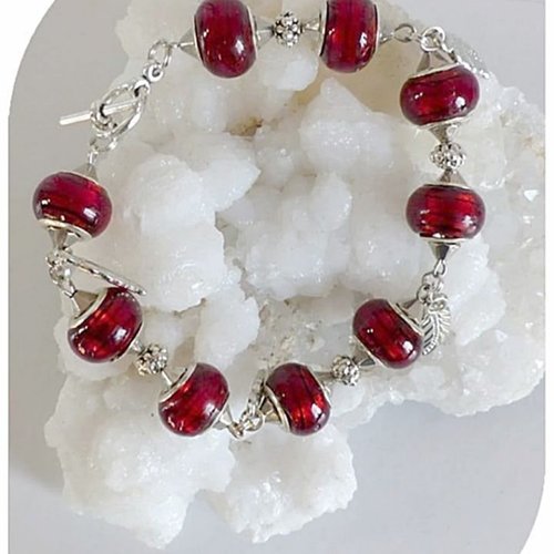 Bracelet perles de verre rouges , fermoir toggle et breloques feuilles argentées.