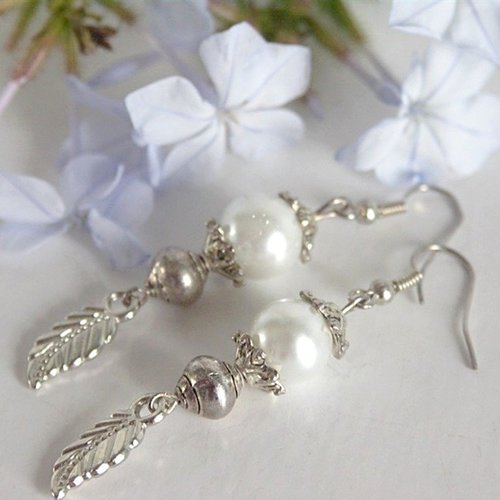 Boucles d'oreilles perles de verre blanches et breloque feuilles . crochets argentés.
