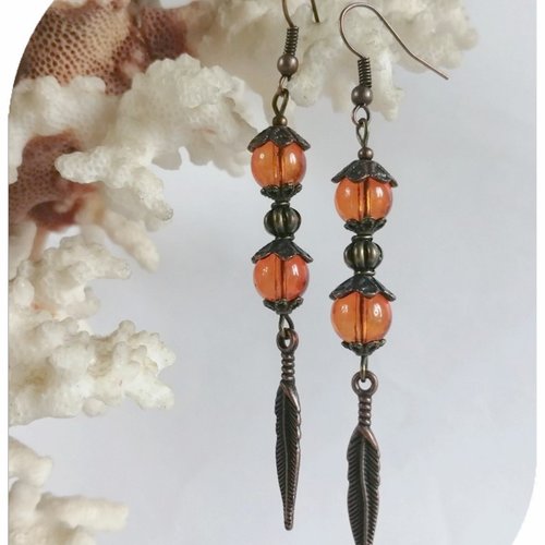 Boucles d'oreilles perles de verre oranges et breloques plumes .