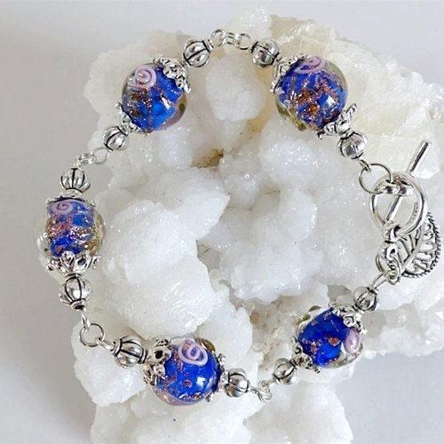 Bracelet perles bleues motifs roses et bronze , breloque feuille .