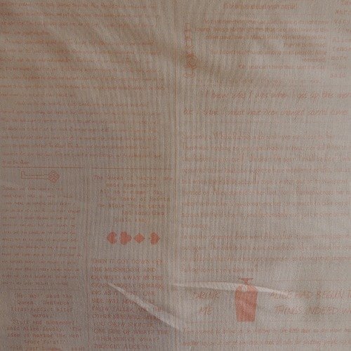 Coupon de tissu coton  fond saumon motif ecritures orange