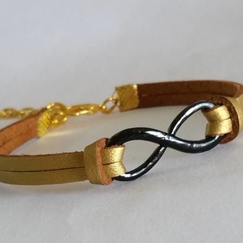Bracelet infini noir avec cordon cuir suédé doré métallisé,  sigle noir, fermoir mousqueton et chaînette de rallonge 