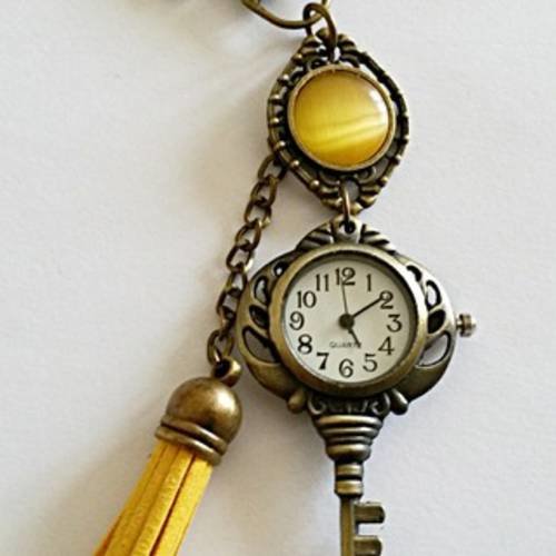 Bijou de sac/porte clés "montre" bronze et jaune d'or, clé bronze, cabochon oeil de chat et pompon jaune d'or