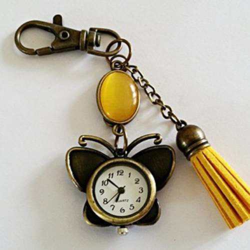 Bijou de sac/porte clés "montre papillon" bronze et jaune d'or,  papillon bronze, cabochon oeil de chat et pompon jaune