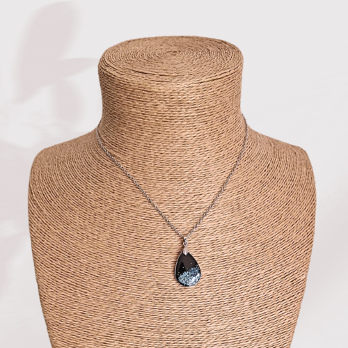 Collier pendentif goutte en polymère noir, son bord argenté et ces paillettes bleu ciel