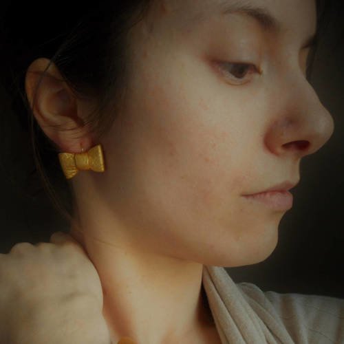 Boucles d'oreilles nœuds origami en cuir doré.