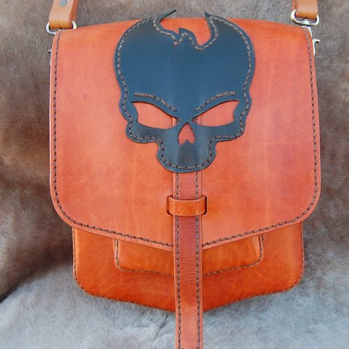 Sac à main en cuir avec motif tête de mort sur le rabat.