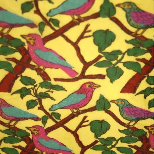 Serviette en papier motif coloré, dessins oiseaux et branchages sur fond jaune 
