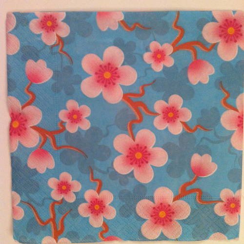 Serviette en papier motif branches et fleurs de cerisier roses sur fond bleu turquoise 