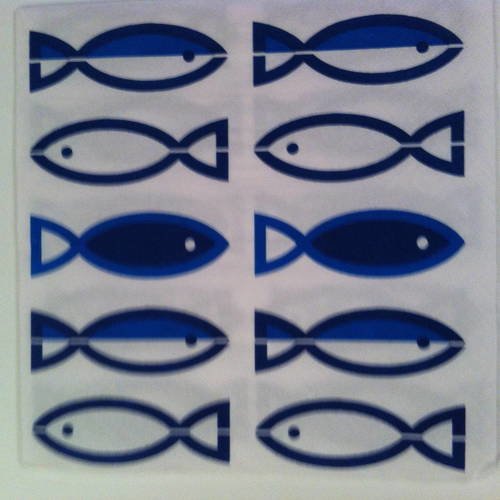 Serviette en papier motif poissons stylisés bleus sur fond blanc 
