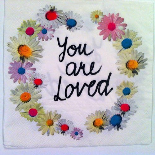 Serviette en papier motif " you are loved" avec une couronne de marguerites colorées sur fond blanc