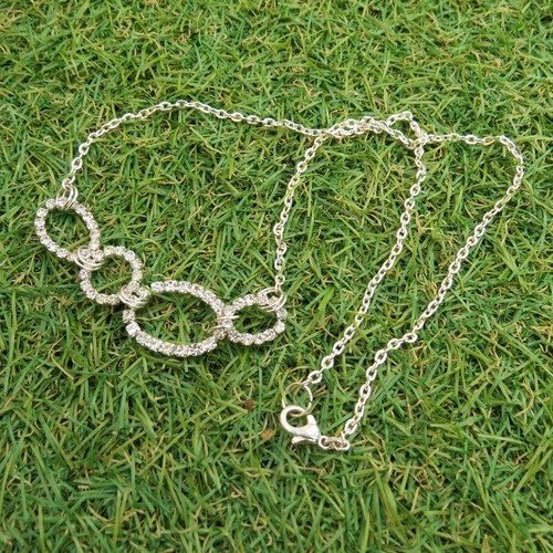 Collier mi-long chaîne métal couleur argent cercle rond et ovale  sertis de strass.