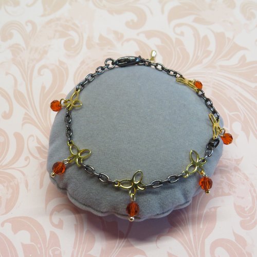 Bracelet gourmette chaîne força métal noir, perles facetté orange et petit papillon doré.