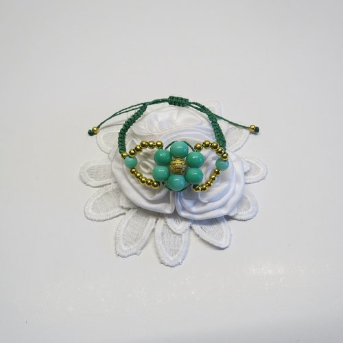 Bracelet micro macramé fils vert et perles en verre verte et petites perles en métal doré tissé à la main forme de fleur.