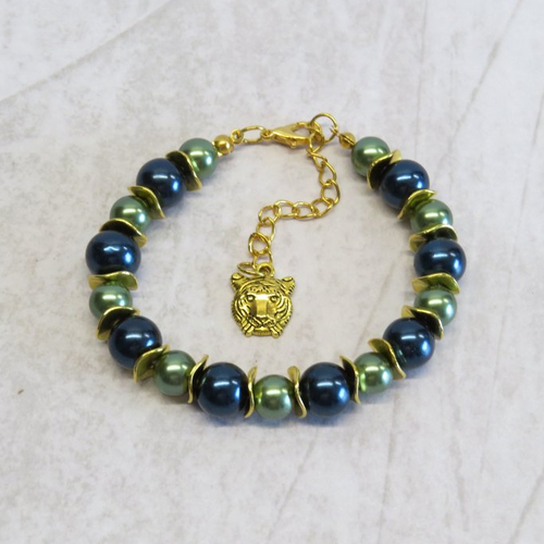 Bracelet perles de verre bleu foncé et vert sapin nacré, breloque tête de tigre doré.